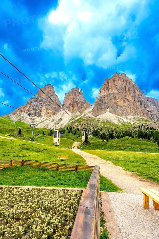 Cable cars transporting tourists up the scenic sella pass in the dolomites, italy, during a beautiful summer day