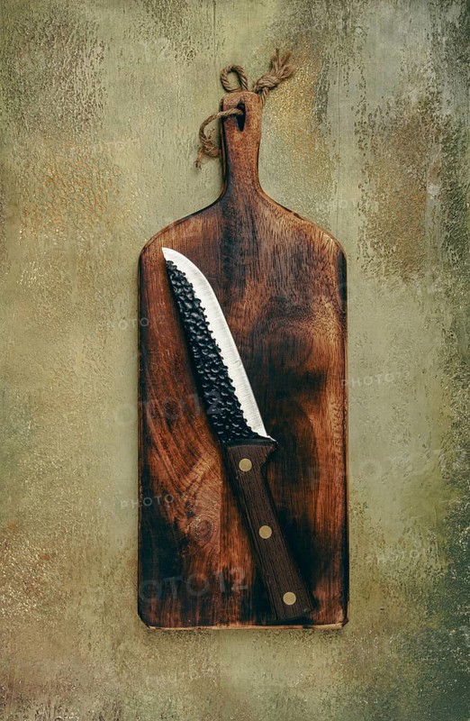 A rustic wooden cutting board displays a sharp knife resting diagonally. The textured background adds warmth to the kitchen atmosphere, inviting culinary creativity
