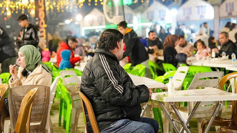 Muslim families and individuals gather at outdoor tables for a mass community Iftar meal under festive Ramadan lights in Gaziantep, Turkey on March 11, 2026, Gaziantep, Turkey