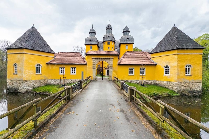 Schloss Holte, Schloss Holte-Stukenbrock, North Rhine-Westphalia, Germany, Baroque yellow castle, hunting lodge with towers and moat under a grey sky