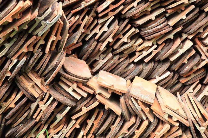 Old roof tiles stored on stockpiles for reuse on historic buildings and heritage-protected houses, beaver tail tiles, clay tiles