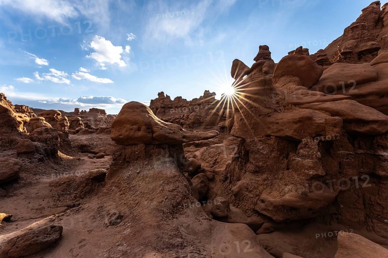 Goblin Valley State Park in Utah features unique rock formations glowing under the sun's rays. The intricate sandstone landscape creates a captivating and surreal natural scene