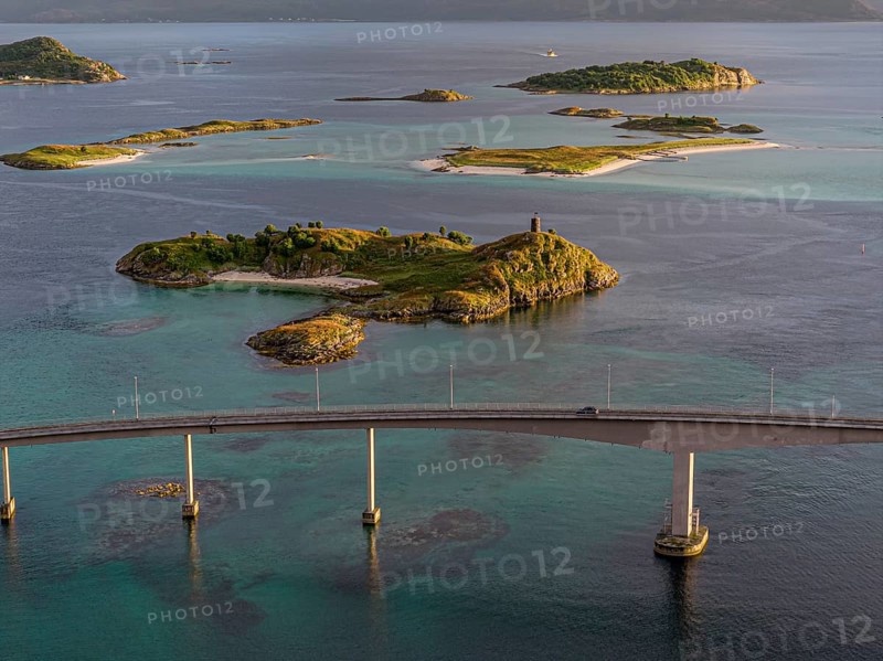 Sommaroy Bridge connecting Kvaloya Island to Sommaroy Island, warm light at sunset, aerial view, Norway