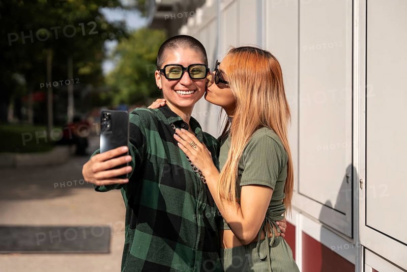 A joyful Colombian lesbian couple takes a selfie outdoors, showcasing their love and happiness. This image celebrates diversity, equality, and LGBTQIA+ pride