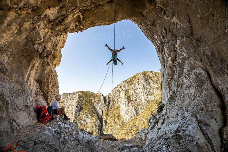 A man is engaging in mountaineering and rappelling activities at Eagleâ€™s Nest, Monterrey, Mexico. The stunning natural rock formations provide an exhilarating backdrop