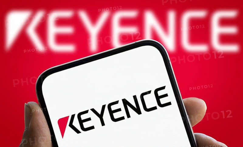 Keyence logo is displayed on smartphone. Keyence is a Japanese company that manufactures automation equipment and precision instruments.