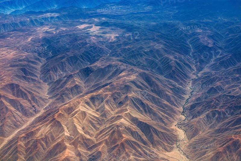 Breathtaking mountain formations in an arid desert region seen from the air, the landscape and desert near Nasca in the Andes of Peru