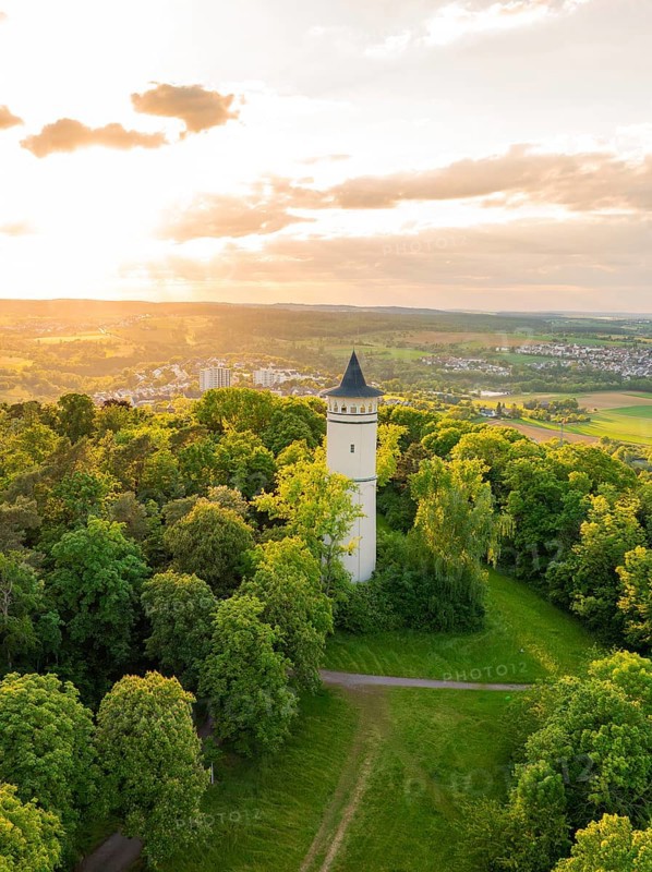 A tower embedded in blossoming trees, flooded with sunset light, Engelberg Tower, Leonberg, Germany