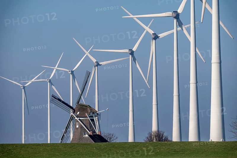 Poldermolen De Goliath windmill stands between the high-tech wind turbines in Eemshaven, historic windmill from around 1882, rebuilt and rebuilt several times, Westereems wind farm, Groningen province, Netherlands