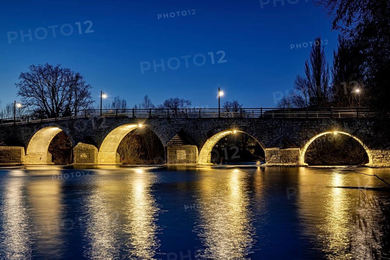 Night view of an illuminated bridge with lights reflecting in the quiet river, The Burgau Bridge in the Saale Valley near Jena in Thuringia