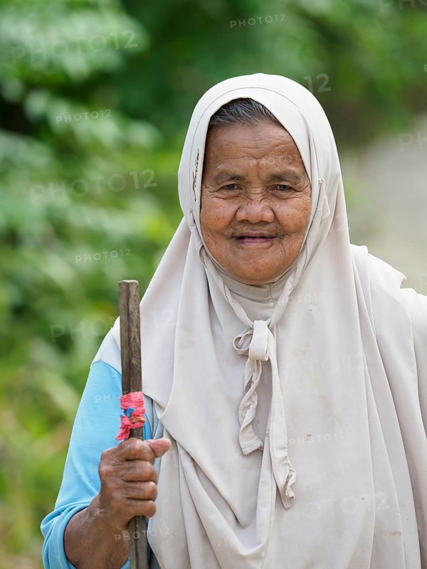Old muslim woman, laughing with stick, Sulawesi, Indonesia