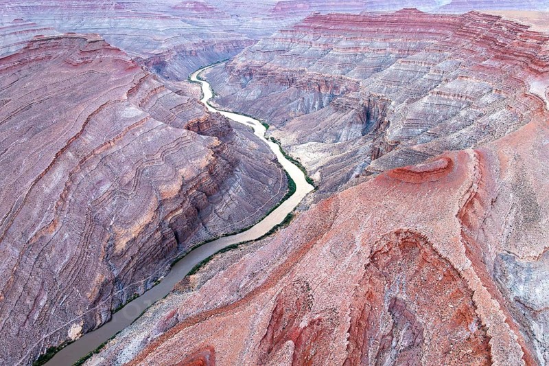 Captivating aerial photograph showcasing the sinuous Rio San Juan cutting through the rugged red landscapes of Utah, USA, revealing nature's intricate patterns and textures