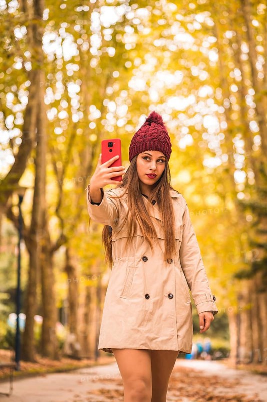 Portrait of a beautiful woman in autumn together in a forest in nature on a video call