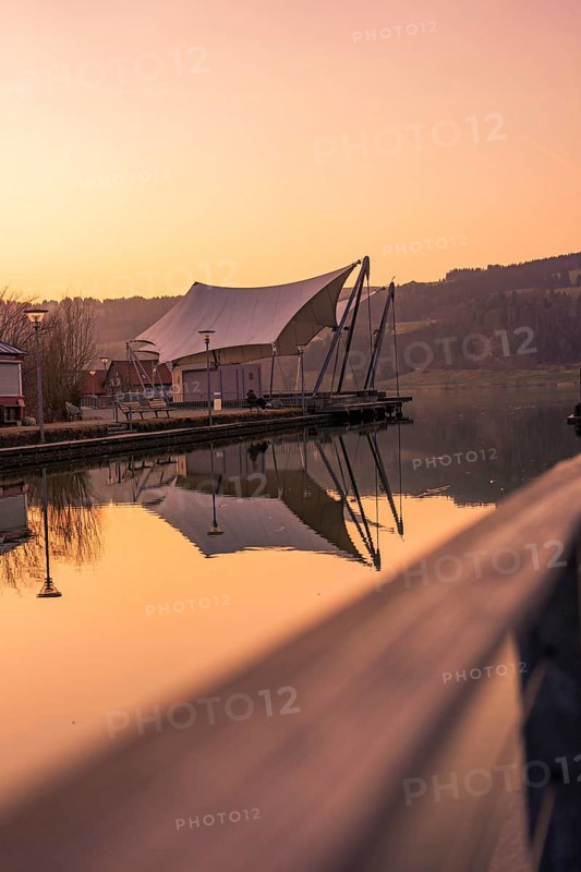 Large tent next to a pier by the lake, quiet atmosphere at dusk and reflection in the water, Großer Alpsee, Immenstadt im Allgäu, Bavaria, Germany