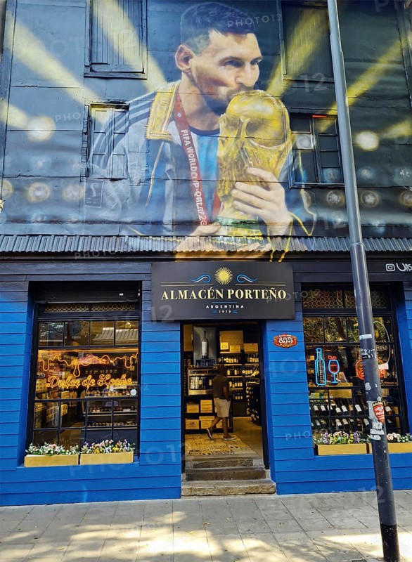 Shop front with a large mural of footballer Lionel Messi with trophy, La Boca neighbourhood, Buenos Aires, Argentina