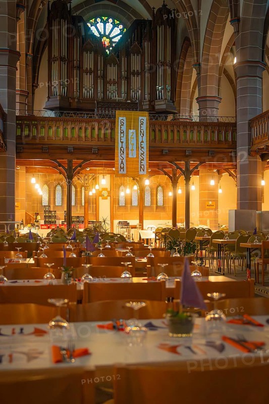 Interior view of a church with organ in the background and laid tables in the foreground, Vesperkirche Calw, Black Forest, Germany