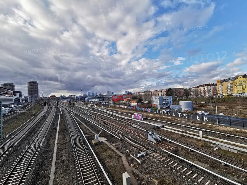 Panorma of urban rail infrastructure under a cloudy sky in summer with city in the background, Berlin