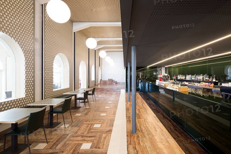 This spacious bar features modern architecture with sleek furniture, elegant lighting, and a polished bar area, creating a stylish and inviting atmosphere