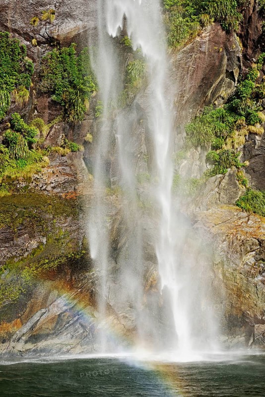 Rainbow over waterfall, Milford Sound, Fiordland National Park, South Island, Southland, New Zealand