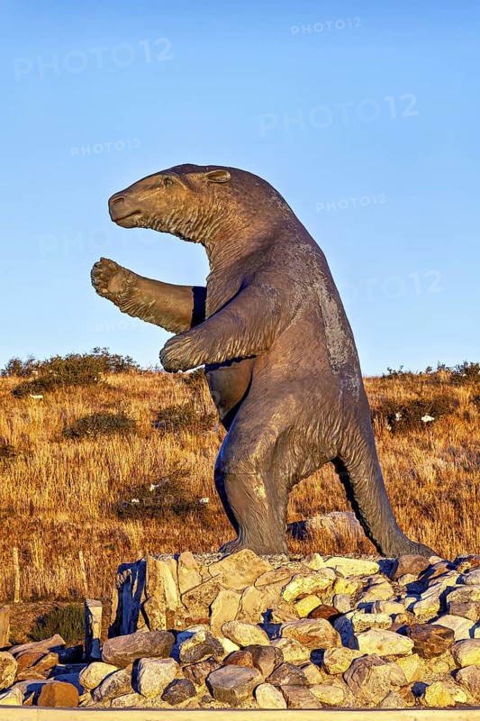 Large sloth statue on a rocky ground in a dry landscape with a clear sky, The statue of the giant sloth near Puerto Natales in Patagonia Chile