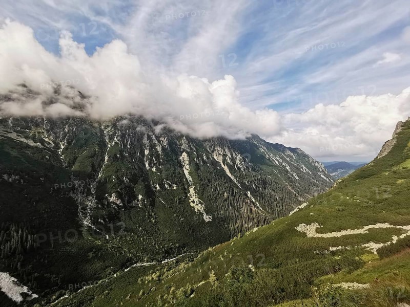 Wide mountain landscape with clouds floating gently above the peaks, Zakopane, hiking in the High Tatras National Park, Carpathian Mountains, Poland