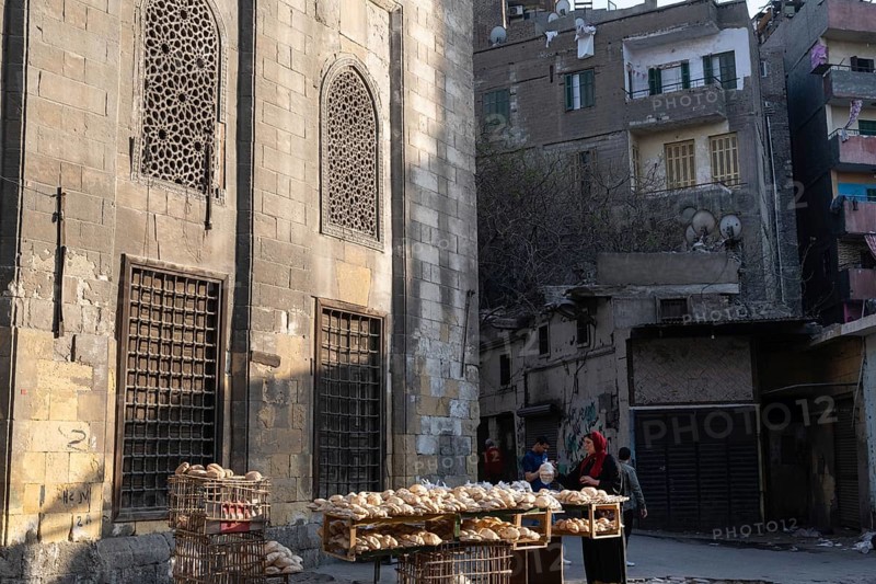 Cairo, Egypt. April 15th 2025. An Egyptian women sells freshly baked Baladi flat bread from a street stall in the crowded Sayeda Zeinab district of Cairo, the Egyptian capital, Egypt