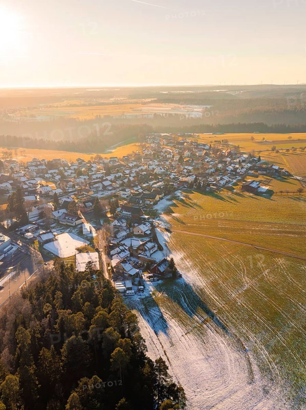 View of a wintry village with fields and forests in the sunset light, Neuweiler, district of Calw, Black Forest, Germany