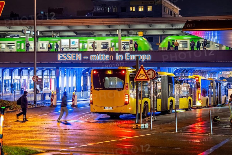 The main train station in Essen, blue illuminated underpass, bus station, am Europaplatz, train on the platform, North Rhine-Westphalia, Germany