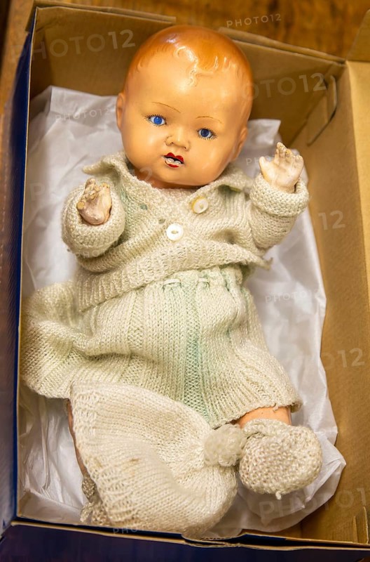 Vintage doll toy in cardboard box on display in auction room, UK