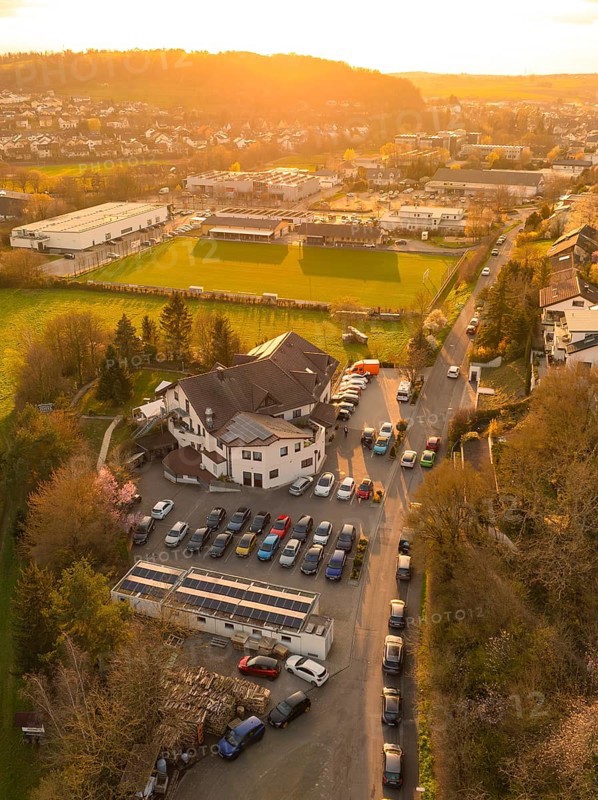 Street with parked cars and surrounding vegetation in a rural setting at sunset, Europäischer Hof, Königsbach, Germany