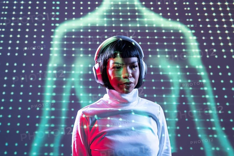 A futuristic Latin woman immersed in music, wearing headphones, against a backdrop of neon lights. She exudes confidence and style in this modern, digital-themed setting
