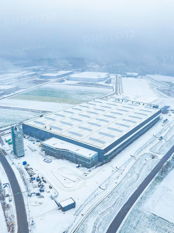 Large industrial plant in the snow, surrounded by roads, seen from the air, gives a sober winter mood, Nagold, Black Forest, Germany