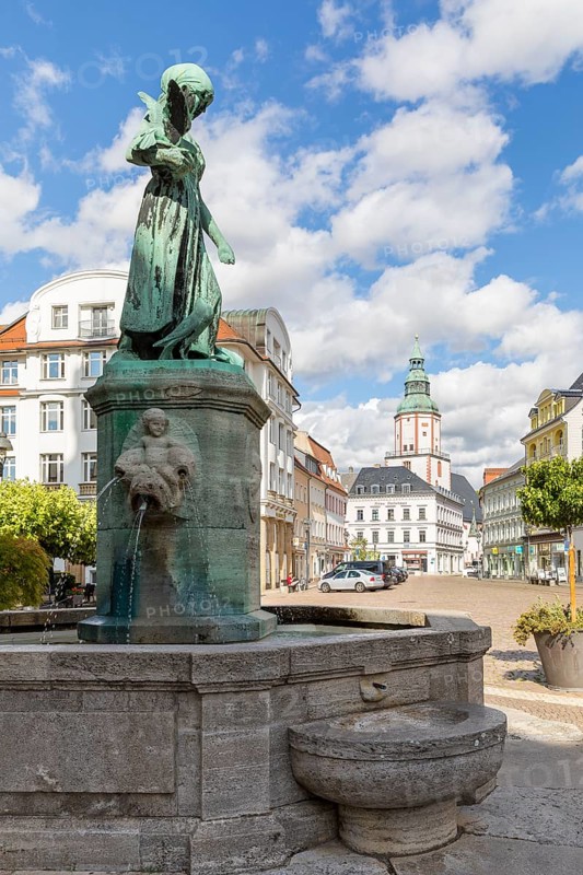 Pigeon girl on the Schlegel fountain in front of the town hall, in the background the Nicolai Church and the Amtshaus, Döbeln, Saxony, Germany