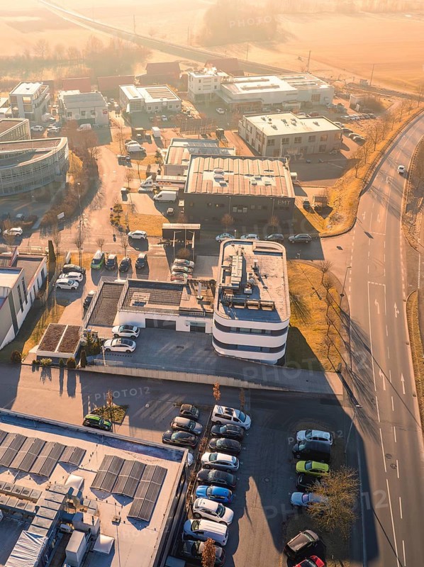 Aerial view of an industrial zone in sunny weather with parked cars and various buildings, Gültstein, Herrenberg, Germany