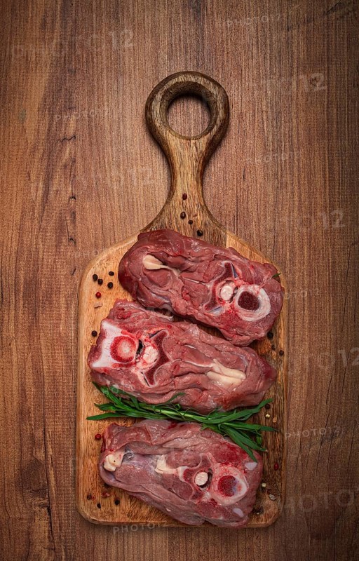 Raw steak, calf's neck on the bone, fresh meat, on the cutting board, top view, no people