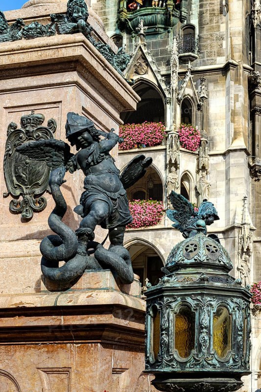 Depiction of allegorical battles against monsters, sculptures at the foot of St Mary's Column, with the town hall in the background, on Marienplatz in Munich, Bavaria, Germany