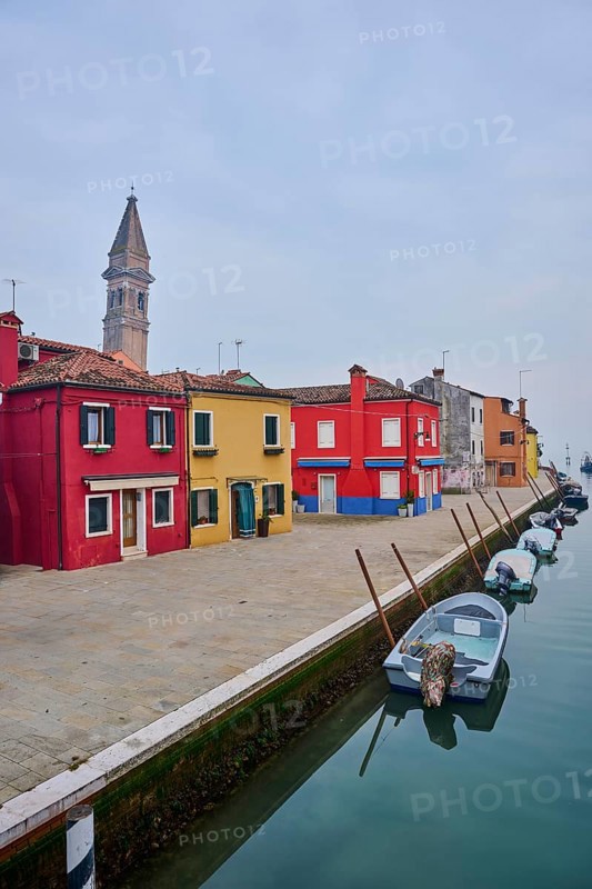 Colorful houses beside the waterway at 'Fondamenta di Pizzo' with boats lying in the water on the island of Burano, Italy