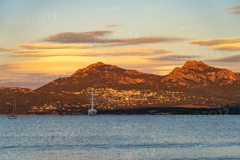 View of Lumio, sailing cruise ship Wind Spirit and the mountains at Calvi Bay, Balagne, Corsica, France