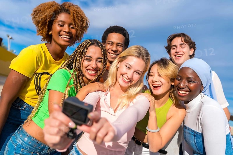 Frontal photo of a multi-ethnic friends taking a selfie with a gopro camera