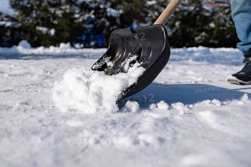 Black shovel removing snow from the sidewalk, Poland