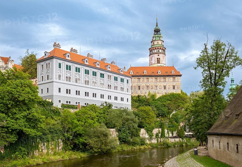 View of the Ceský Krumlov Castle with tower, colorful facade buildings, Vltava River, and greenery, Cesky Krumlov, Czech Republic