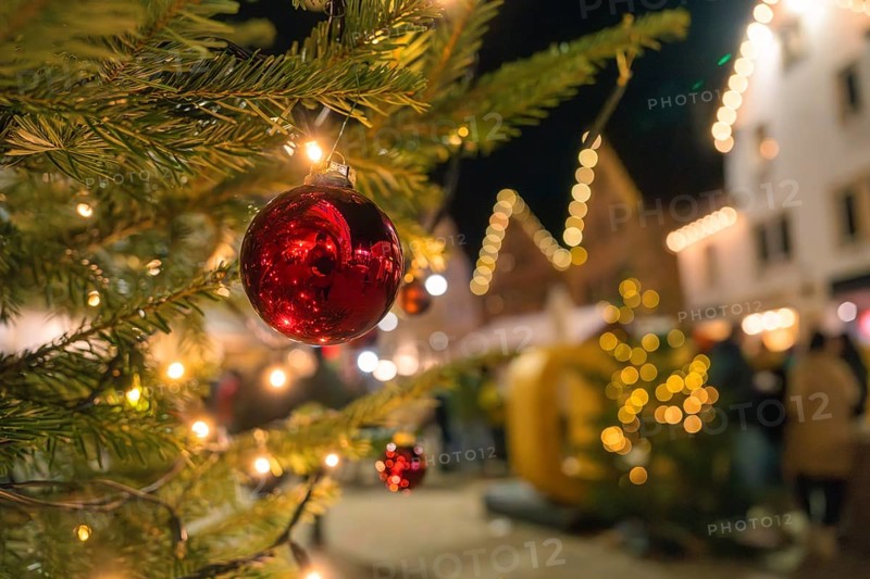 Night shot of a red Christmas bauble on a tree with fairy lights, Christmas market Nagold, Black Forest, Germany