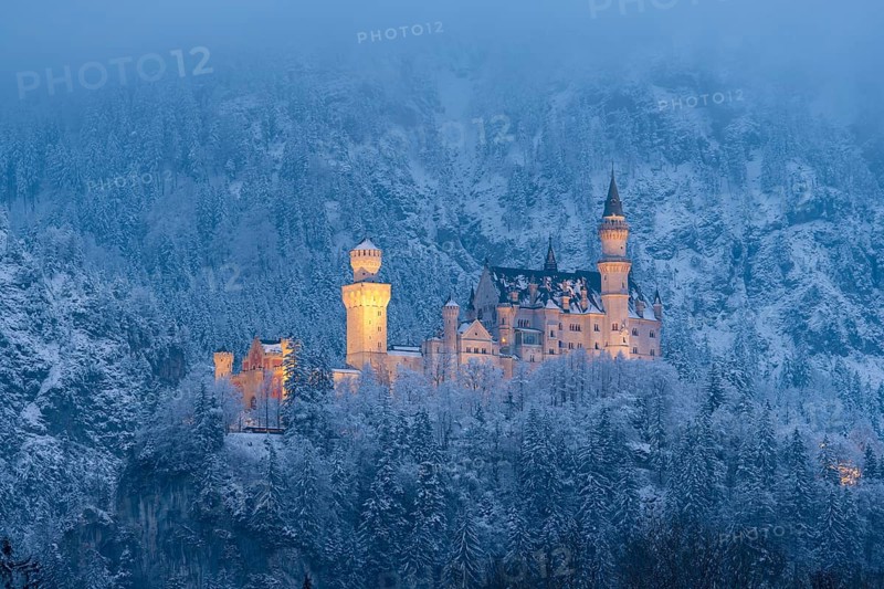 The illuminated castle appears mystical in a snow-covered landscape at night, Neuschwanstein, Schwangau, Ostallgäu, Allgäu, Swabia, Upper Bavaria, Bavaria, Germany