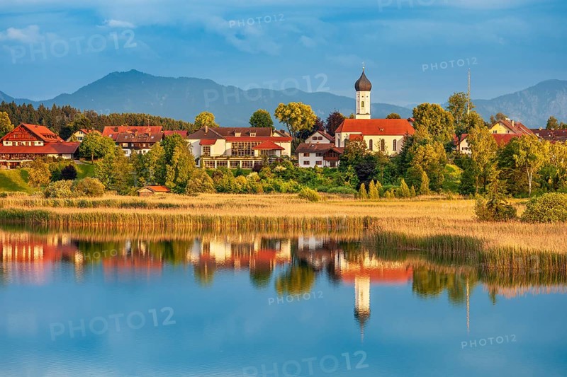 View over the Sengsee lake to Iffeldorf with St. Vitus church in autumn, Osterseen, Fünfseenland, Upper Bavaria, Bavaria, Germany