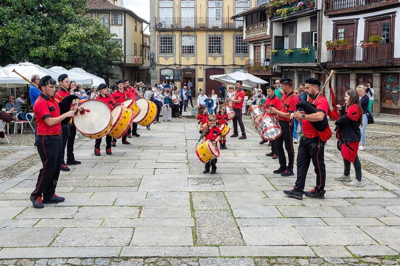 Traditional drum and pipe band perform on city streets on May Day 2025, Guimaraes, Braga district, northern Portugal