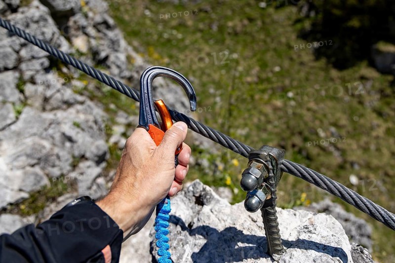 Hand attaching a via ferrata carabiner to the steel cable of a via ferrata, Jenner, Berchtesgaden National Park, Schönau am Königssee, Upper Bavaria, Bavaria, Germany