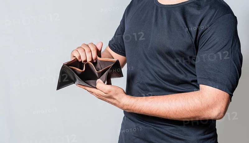Hands of bankrupt person showing an empty wallet isolated. Man's hands in financial crisis showing wallet