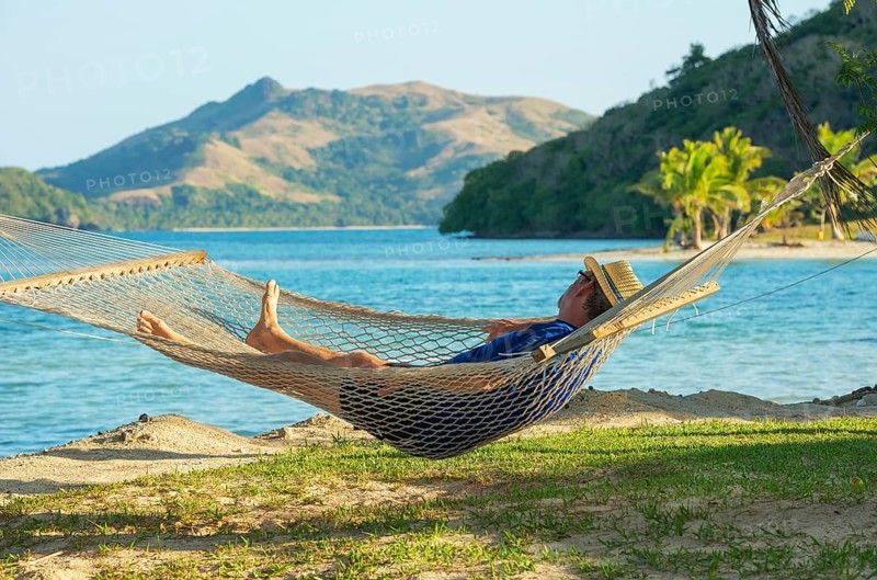 Man relaxing in hammock and enjoying sea view, Yasawa islands, Fiji
