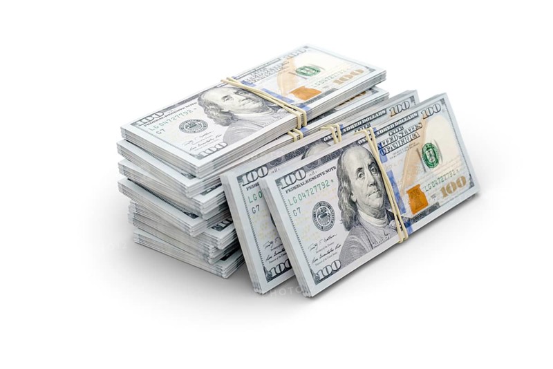 Stacks of thousands of one hundred dollar bills bound by a rubber band isolated on a white background