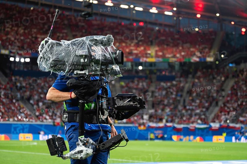 Man carries TV camera on the stabilizer at football stadium